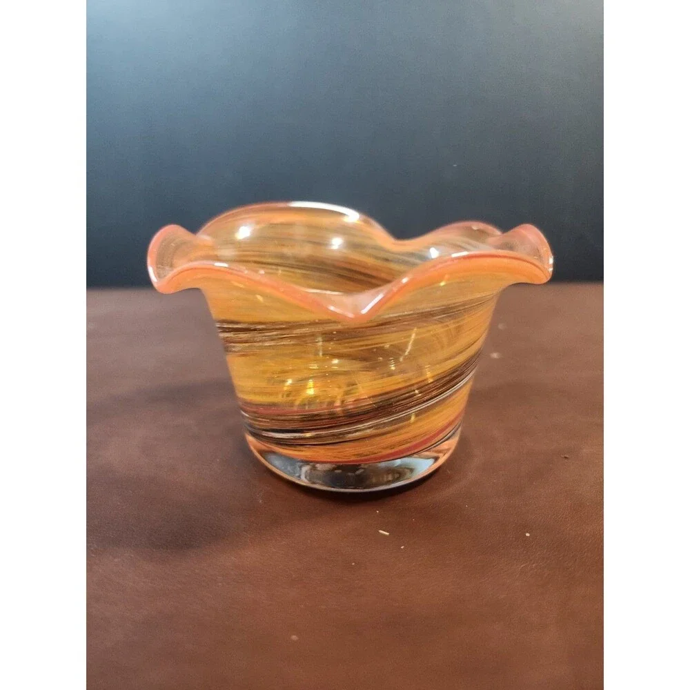 hand-blown art glass bowl features a vibrant orange and amber swirl pattern with